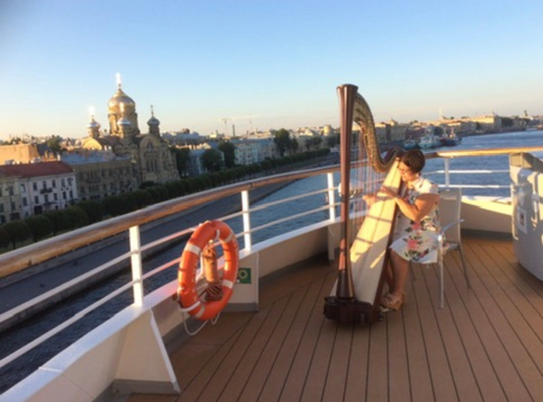 Helen-Elizabeth playing a harp on a ship deck