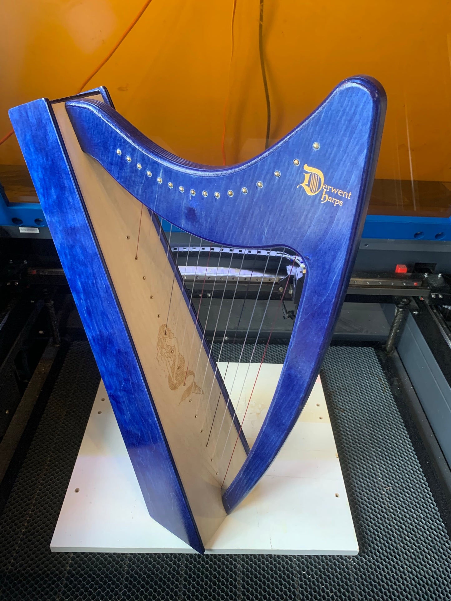 Derwent Harps Discovery 16 harp in blue with a mermaid engraved on soundboard.